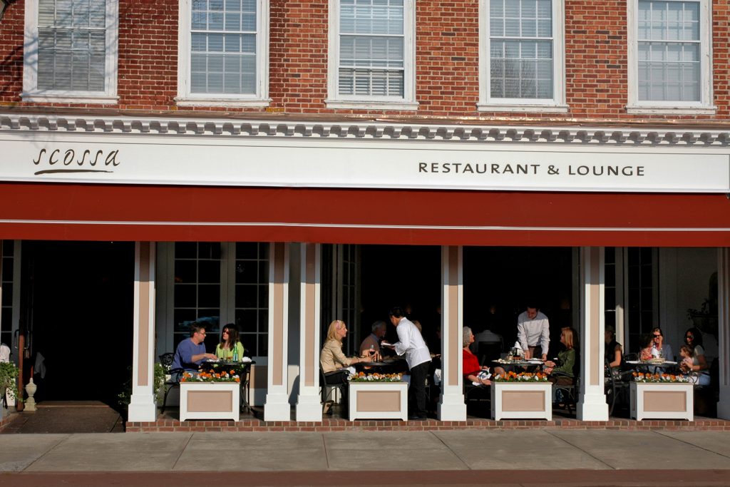 Scossa Cafe A brick building with a red awning constructed by Willow Construction.